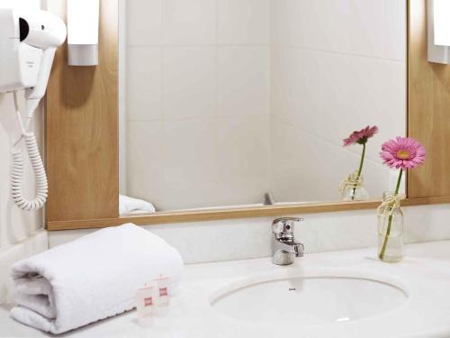 a bathroom with a sink and a mirror at ibis Novo Hamburgo in Novo Hamburgo