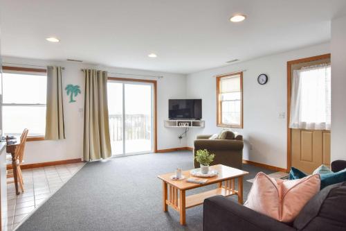 a living room with a couch and a table at 12216 - Beautiful Views of Cape Cod Bay Access to Private Beach Easy Access to P-Town in Truro