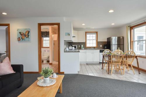 a living room and kitchen with a couch and a table at 12216 - Beautiful Views of Cape Cod Bay Access to Private Beach Easy Access to P-Town in Truro
