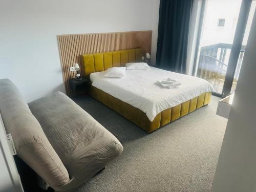 um quarto de hotel com uma cama e um sofá em GRAND Caciulata em Caciulata