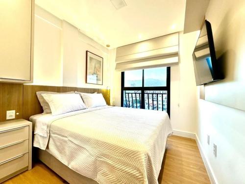 B258 - Apto de luxo com vista mar em Bombinhas في بومباس: غرفة نوم صغيرة بها سرير وتلفزيون