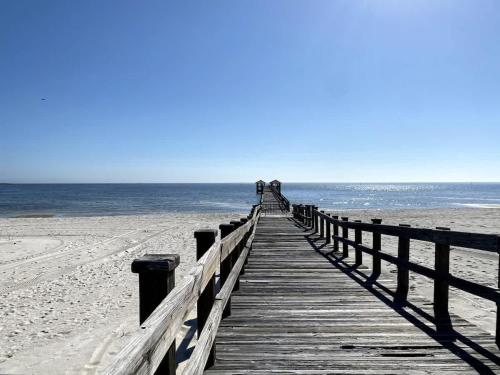 a boardwalk leading to the beach with people on it at White Sand Getaway steps from Beach in Gulfport