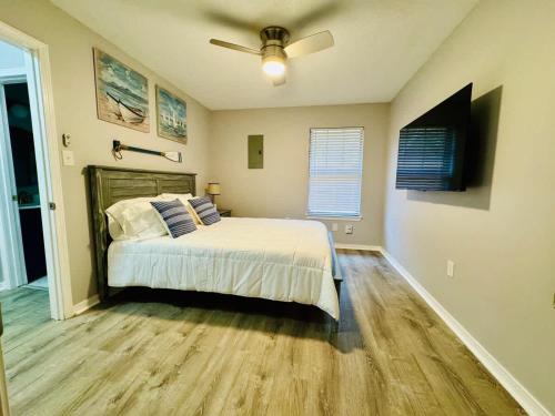 a bedroom with a bed and a ceiling fan at NEW Getaway by Gulfport Beach in Gulfport