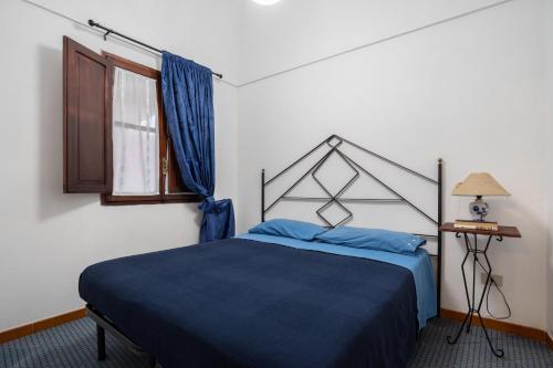 een slaapkamer met een blauw bed en een raam bij Appartamento Esperanza Amarillo in Scauri