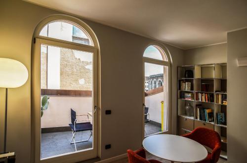 a living room with a table and two windows at Arena's Hospitality in Verona