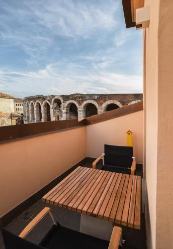 a balcony with a wooden table and a chair at Arena's Hospitality in Verona