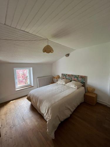 a bedroom with a large bed with a ceiling at Maison Charentaise 12 à 14 personnes in Sémussac