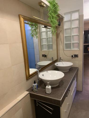 ein Badezimmer mit zwei Waschbecken und einem großen Spiegel in der Unterkunft Franky Home in Mailand