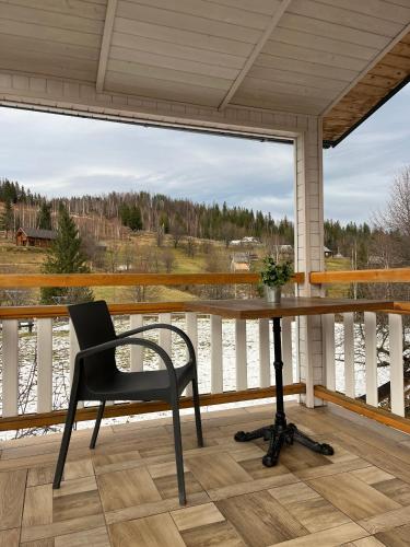 SnidavkaにあるСироварня Далекі Гориのポーチに置かれた机と椅子と窓