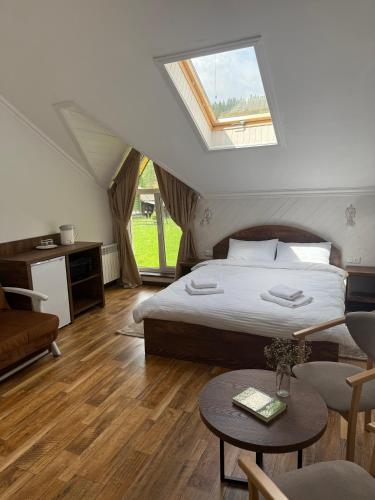 Un dormitorio con una cama, un sofá y una mesa. en Сироварня Далекі Гори, en Snidavka