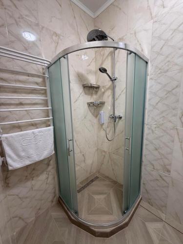 una ducha con puerta de cristal en un baño en Сироварня Далекі Гори, en Snidavka