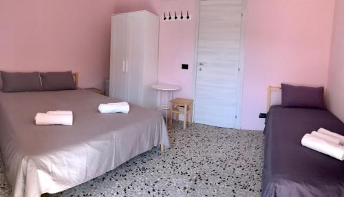 two beds in a room with pink walls at Accommodates 5 people between Ibla and Ragusa in Ragusa