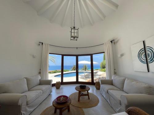 a living room with white furniture and a view of the ocean at Villa Florencia in Son Bou