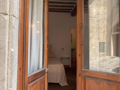 una porta aperta che conduce a una camera con letto di Casa Cerboneschi a Casale Marittimo