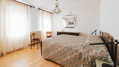 a bedroom with a bed and a table and a chair at In-giardino in Osigo