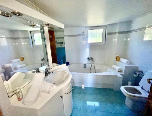 a bathroom with a tub and a sink and a toilet at Art Blue Residence - Panorama Maisonette in Aghia Marina