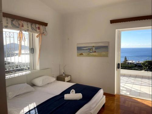 a bedroom with a bed with a view of the ocean at Art Blue Residence - Panorama Maisonette in Aghia Marina
