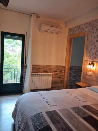 a bedroom with a bed and a large window at Hostal La Pastora in Candeleda