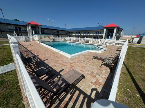 a swimming pool with chairs and a swimming poolvisor at Englewood Inn & Suites in Englewood