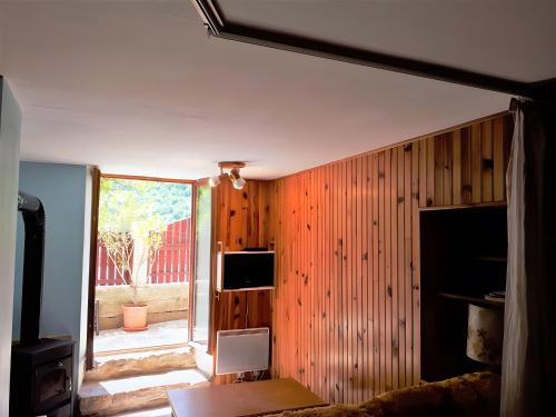 a living room with wood paneled walls and a television at Gite Le Vignou À Ste-enimie in Prades