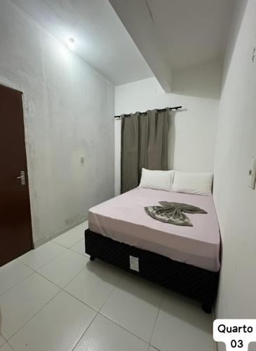 una camera da letto con un letto in una stanza bianca di Casa Fundo de Quintal a Trairi