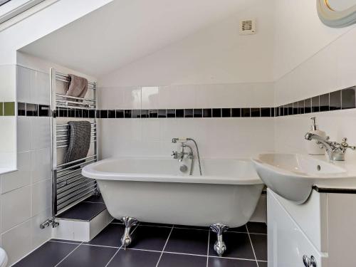 un bagno bianco con vasca e lavandino di 5 Bed in Conwy 48169 a Eglwys-Fâch
