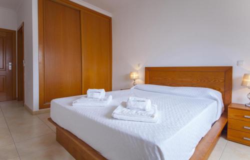 ein Schlafzimmer mit einem weißen Bett mit zwei Handtüchern darauf in der Unterkunft B41 - Windmill Modern with Pool in Lagos