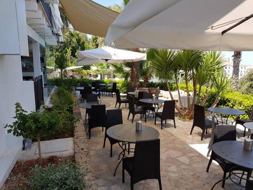 an outdoor patio with tables and chairs and umbrellas at Albergo Villa Vittoria in Rodi Garganico