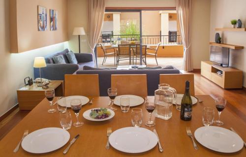 a dining room table with plates and wine glasses at B27 - LuzBay 2 Bed Apartment in Luz
