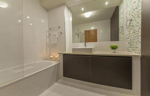 ein Badezimmer mit Waschbecken, Badewanne und Spiegel in der Unterkunft B27 - LuzBay 2 Bed Apartment in Luz
