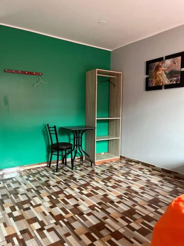 a room with a table and chairs and a green wall at Hotel PRADO'S in Satipo
