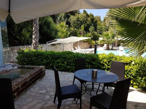 a patio with a table and chairs and a pool at Albergo Villa Vittoria in Rodi Garganico