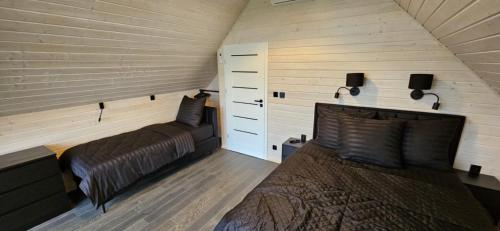 a bedroom with a bed and two lights on the wall at Black barn in Rusinowo