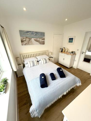 una camera da letto con un letto grande con cuscini blu di Salcombe Bolthole Room a Salcombe