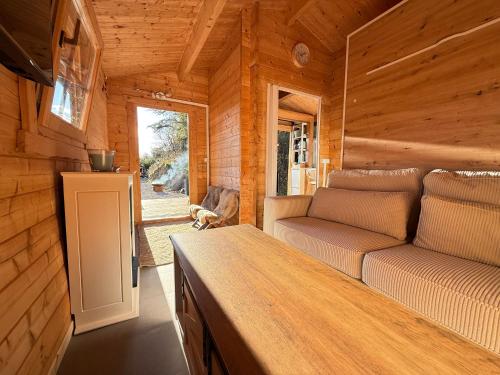 Una sala de estar de una cabaña de troncos con un sofá. en Chalet d hiver, en Millau