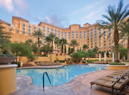a resort with a large pool and palm trees at Wyndham Grand Desert -3BR - Apartment With Resort Access in Las Vegas