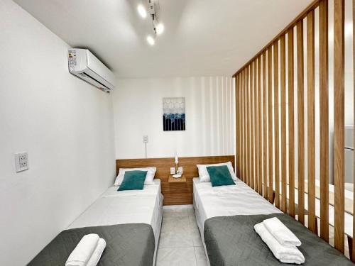 a room with two beds in a room with a window at Vela Villa Apart in Villa Ángela