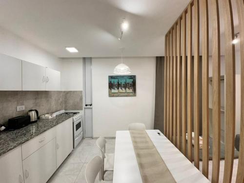 una cucina con tavolo bianco in una camera di Vela Villa Apart a Villa Ángela