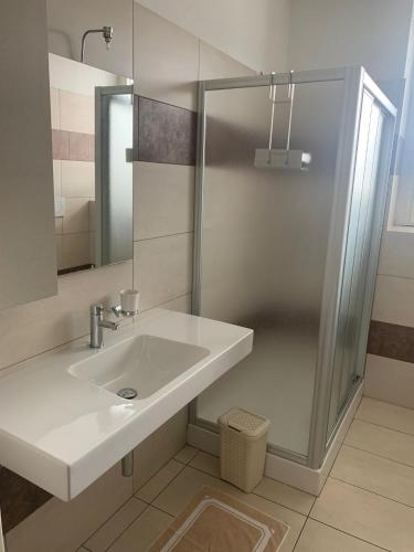 a white bathroom with a sink and a shower at Caterina in Bergamo