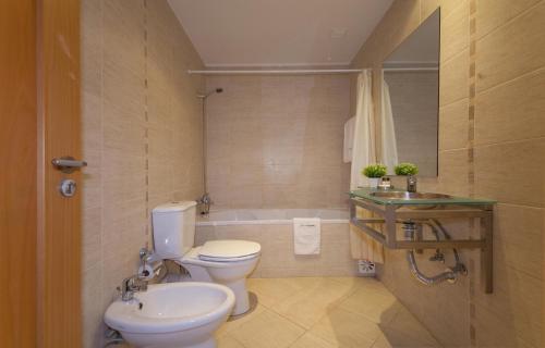 a bathroom with a toilet and a sink and a tub at B42 - Oceano Atlantico Apartment in Portimão