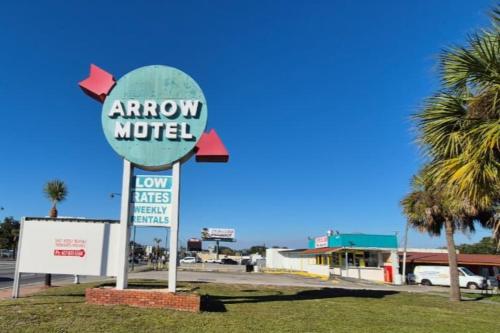 Un cartel de un motel Arrow en un estacionamiento. en Arrow Motel by OYO Near Downtown, en Orlando