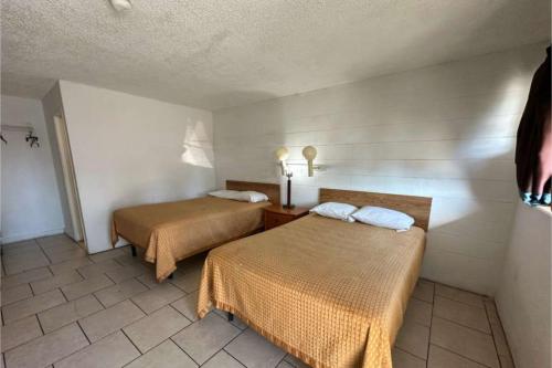 una habitación con dos camas en una habitación en Arrow Motel by OYO Near Downtown, en Orlando