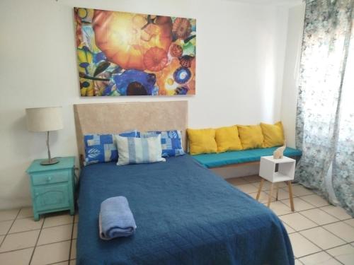 a bedroom with a blue bed and a couch at Habitación privada en casa de huespedes in Guadalajara