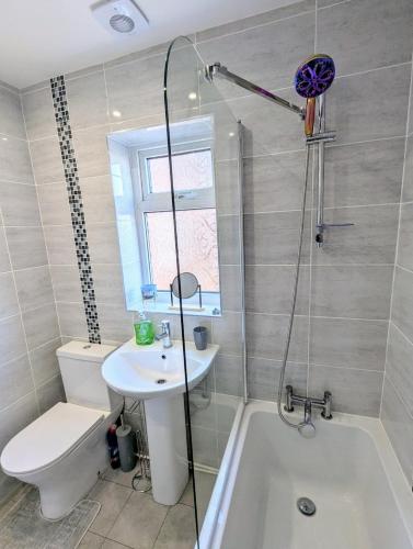 a bathroom with a sink and a toilet and a bath tub at Castleford nest 3 bed driveway 2 Free Parking 6ppl in Featherstone