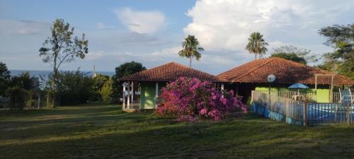 una casa con fiori rosa davanti a un cortile di Pousada e Restaurante Cajutuba a Belterra