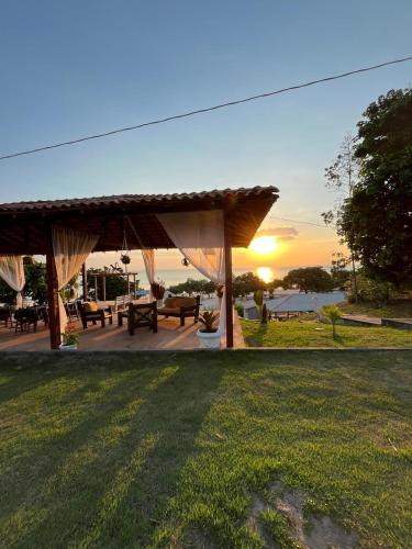 a gazebo with a sunset in the background at Pousada e Restaurante Cajutuba in Belterra