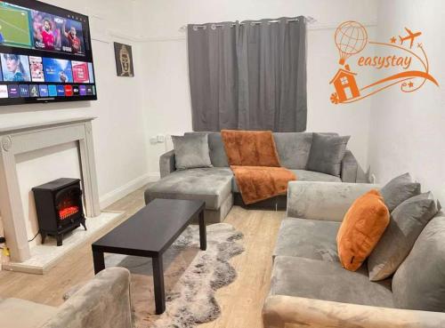 a living room with a couch and a fireplace at Easystays The Hidden Gem Large Basic Home Can Sleep 15 in Braunstone