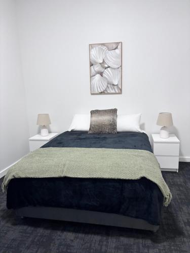 a white bedroom with a large bed and two lamps at The Club Hotel Collie in Collie