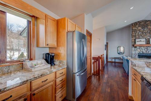 a kitchen with a stainless steel refrigerator and wooden cabinets at Hill Station in Beech Mountain