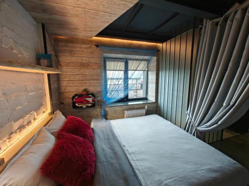 um quarto com uma cama em um quarto com janela em loft apartments OLD MILL em Sarny